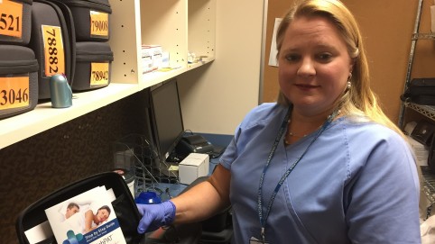 Nurse displaying sleep monitor in a case. 